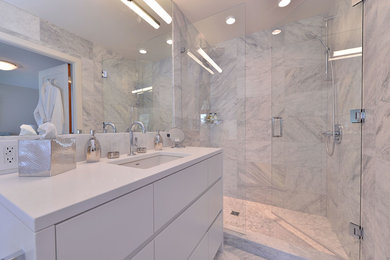 Small minimalist master multicolored tile and stone tile marble floor bathroom photo in Vancouver with flat-panel cabinets, white cabinets, an undermount sink, quartz countertops, a one-piece toilet and white walls