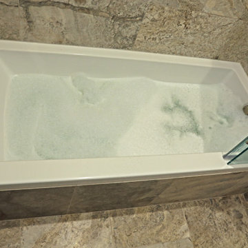 Deep soaker tub with fold-away enclosure