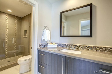 Diseño de cuarto de baño contemporáneo con armarios con paneles lisos y baldosas y/o azulejos en mosaico