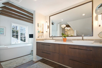 Inspiration for a large scandinavian master beige tile and porcelain tile wood-look tile floor, white floor, double-sink and exposed beam freestanding bathtub remodel in Cleveland with flat-panel cabinets, dark wood cabinets, a one-piece toilet, white walls, a vessel sink, quartzite countertops, white countertops and a floating vanity