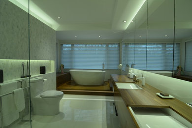 Example of a large trendy master white tile and porcelain tile porcelain tile bathroom design in Montreal with flat-panel cabinets, dark wood cabinets, a one-piece toilet, an undermount sink and wood countertops