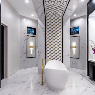 Geräumiges Klassisches Badezimmer En Suite mit verzierten Schränken, schwarzen Schränken, freistehender Badewanne, bodengleicher Dusche, Wandtoilette, schwarz-weißen Fliesen, Porzellanfliesen, weißer Wandfarbe, Porzellan-Bodenfliesen, Unterbauwaschbecken, Quarzwerkstein-Waschtisch, weißem Boden, Falttür-Duschabtrennung und weißer Waschtischplatte