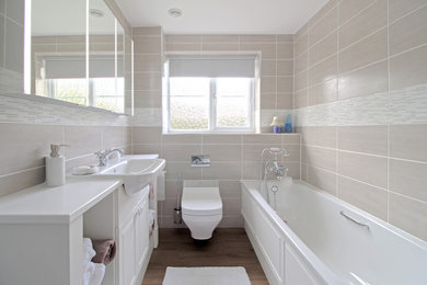 Photo of a small traditional family bathroom in Essex with beaded cabinets, white cabinets, a wall mounted toilet, grey tiles, ceramic tiles, grey walls and laminate floors.