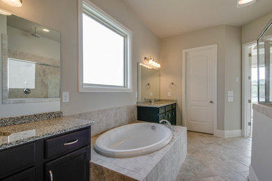 Photo of a medium sized traditional ensuite bathroom in Nashville with recessed-panel cabinets, dark wood cabinets, a built-in bath, a corner shower, a two-piece toilet, beige walls, ceramic flooring, a submerged sink and laminate worktops.