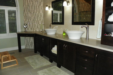 Mid-sized elegant master ceramic tile bathroom photo in Indianapolis with beige walls, a vessel sink, dark wood cabinets, quartz countertops and glass-front cabinets
