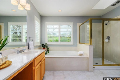 Example of a mid-sized trendy master gray tile and porcelain tile corner shower design in San Francisco with raised-panel cabinets, gray cabinets and onyx countertops