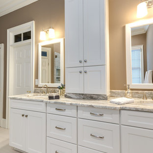 Example of a large transitional master beige tile and porcelain tile porcelain tile, white floor and double-sink bathroom design in Atlanta with an undermount sink, recessed-panel cabinets, white cabinets, beige walls, quartzite countertops, a hinged shower door, white countertops, a built-in vanity and a two-piece toilet