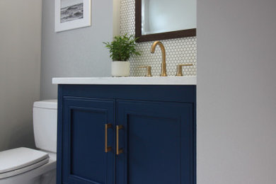 This is an example of a small classic half tiled bathroom in Providence with freestanding cabinets, blue cabinets, a two-piece toilet, white tiles, porcelain tiles, grey walls, porcelain flooring, a submerged sink, quartz worktops, multi-coloured floors and white worktops.