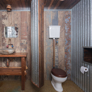 Photo of an industrial bathroom in Canberra - Queanbeyan with open cabinets, medium wood cabinets, a two-piece toilet, brown walls, concrete floors, a vessel sink, wood benchtops, brown benchtops and brown floor.