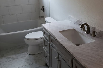 Bathroom - mid-sized traditional kids' white tile and porcelain tile porcelain tile and multicolored floor bathroom idea in San Francisco with raised-panel cabinets, gray cabinets, a two-piece toilet, gray walls, an undermount sink, granite countertops and gray countertops