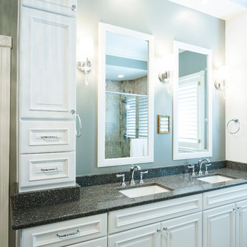 Double vanity with tower cabinets, light sconces, and double mirrors