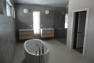Bathroom - large modern master gray tile beige floor and porcelain tile bathroom idea in Chicago with flat-panel cabinets, light wood cabinets, gray walls, quartz countertops, a hinged shower door, white countertops and an integrated sink