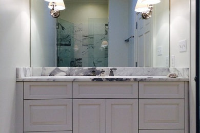 Imagen de cuarto de baño principal tradicional renovado con puertas de armario blancas, paredes blancas, suelo de mármol, encimera de mármol y lavabo bajoencimera