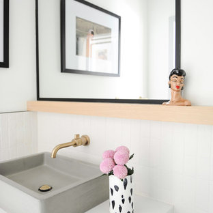 Diseño de cuarto de baño con ducha, bohemio, de tamaño medio, con armarios con paneles lisos, puertas de armario de madera clara, bañera empotrada, combinación de ducha y bañera, sanitario de una pieza, paredes blancas, suelo de azulejos de cemento, lavabo sobreencimera, encimera de cuarcita, suelo multicolor, ducha abierta y encimeras blancas