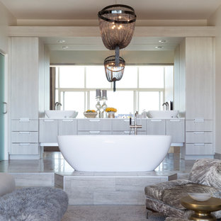 Example of a large trendy master freestanding bathtub design in Other with flat-panel cabinets, gray cabinets, a vessel sink, quartz countertops and beige walls