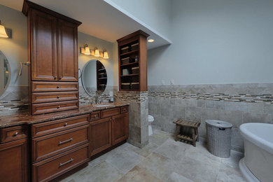 Inspiration for a large transitional master gray tile and porcelain tile porcelain tile bathroom remodel in Philadelphia with an undermount sink, raised-panel cabinets, dark wood cabinets, granite countertops, a two-piece toilet and gray walls