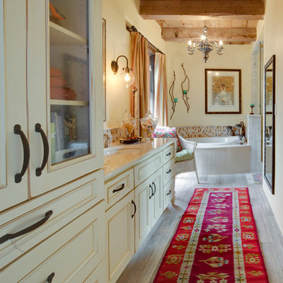 Large southwest master beige tile, blue tile, brown tile and ceramic tile porcelain tile drop-in bathtub photo in Albuquerque with recessed-panel cabinets, beige cabinets, yellow walls and an undermount sink