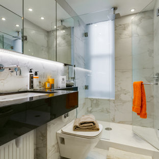 Medium sized contemporary shower room bathroom in London with open cabinets, black cabinets, an alcove shower, a wall mounted toilet, grey tiles, porcelain tiles, porcelain flooring, a submerged sink, grey floors, a hinged door and black worktops.