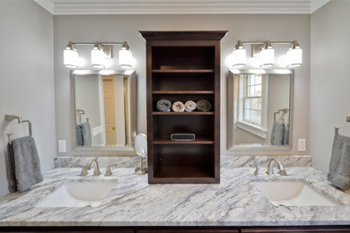 Alcove shower - large contemporary master beige tile and ceramic tile light wood floor and brown floor alcove shower idea in New York with shaker cabinets, brown cabinets, a one-piece toilet, gray walls, an undermount sink, granite countertops, a hinged shower door and multicolored countertops