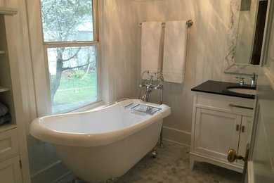 Photo of a medium sized classic bathroom in Omaha with shaker cabinets, white cabinets, a claw-foot bath, a two-piece toilet, marble flooring, a submerged sink, marble worktops, grey floors and black worktops.