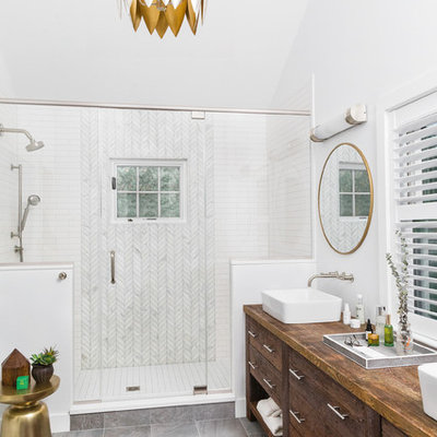 Inspiration for a mid-sized timeless master white tile and subway tile porcelain tile and gray floor doorless shower remodel in Boston with flat-panel cabinets, dark wood cabinets, white walls, a vessel sink, wood countertops, a hinged shower door and brown countertops