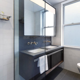 Example of a small minimalist master gray tile and stone slab limestone floor doorless shower design in New York with an undermount sink, flat-panel cabinets, dark wood cabinets, granite countertops, a wall-mount toilet and white walls