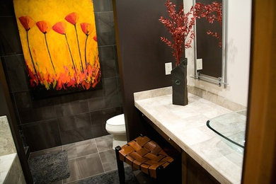 Foto de cuarto de baño de tamaño medio con lavabo sobreencimera, bañera empotrada, sanitario de dos piezas, paredes negras, suelo de baldosas de cerámica y aseo y ducha