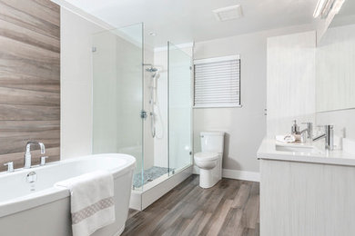Aménagement d'une grande salle de bain principale moderne avec un lavabo encastré, des portes de placard blanches, une baignoire indépendante, une douche d'angle, WC séparés, un mur blanc et parquet foncé.