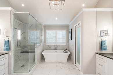 Large transitional master white tile and marble tile marble floor and white floor freestanding bathtub photo in Atlanta with a two-piece toilet, beige walls, an undermount sink, granite countertops and a hinged shower door
