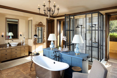 Inspiration for a large mediterranean master medium tone wood floor alcove shower remodel in San Francisco with furniture-like cabinets, medium tone wood cabinets, a vessel sink and a hinged shower door