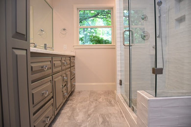 Example of a mid-sized transitional master white tile and subway tile ceramic tile and green floor alcove shower design in Other with raised-panel cabinets, gray cabinets, a two-piece toilet, white walls, an undermount sink, quartzite countertops and a hinged shower door
