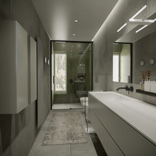 Idee per una grande stanza da bagno con doccia design con ante lisce, ante grigie, doccia alcova, WC sospeso, piastrelle grigie, piastrelle in gres porcellanato, pareti grigie, pavimento in gres porcellanato, lavabo da incasso, top in superficie solida, pavimento grigio, porta doccia scorrevole, top grigio, nicchia, un lavabo, mobile bagno sospeso e soffitto ribassato
