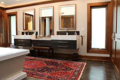 シカゴにあるラグジュアリーな広いコンテンポラリースタイルのおしゃれなマスターバスルーム (フラットパネル扉のキャビネット、濃色木目調キャビネット、置き型浴槽、白い壁、一体型シンク、グレーの床) の写真