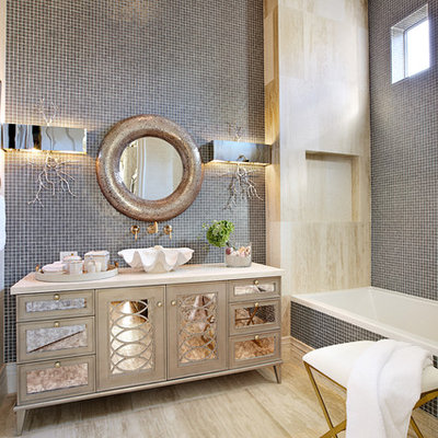 Example of an eclectic gray tile and mosaic tile alcove bathtub design in Las Vegas with a vessel sink, furniture-like cabinets and beige cabinets