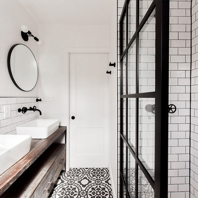 Bathroom - industrial white tile and subway tile cement tile floor and multicolored floor bathroom idea in DC Metro with furniture-like cabinets, medium tone wood cabinets, white walls, a vessel sink, wood countertops and brown countertops