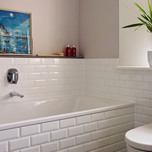 Mittelgroßes Shabby-Style Kinderbad mit Wandwaschbecken, flächenbündigen Schrankfronten, hellbraunen Holzschränken, Einbaubadewanne, bodengleicher Dusche, Toilette mit Aufsatzspülkasten, weißen Fliesen, Porzellanfliesen, brauner Wandfarbe und Keramikboden in Devon