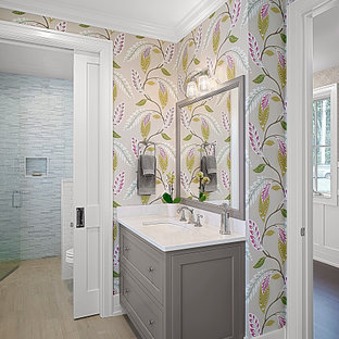Mid-sized elegant blue tile and glass tile ceramic tile, brown floor, single-sink and wallpaper bathroom photo in Grand Rapids with shaker cabinets, gray cabinets, multicolored walls, an undermount sink, quartz countertops, a hinged shower door, white countertops and a built-in vanity