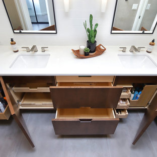 Mid-sized midcentury master bathroom in Phoenix with flat-panel cabinets, medium wood cabinets, a curbless shower, a one-piece toilet, gray tile, porcelain tile, white walls, porcelain floors, an undermount sink, engineered quartz benchtops, grey floor, an open shower, white benchtops, a niche, a double vanity, a built-in vanity and wood walls.