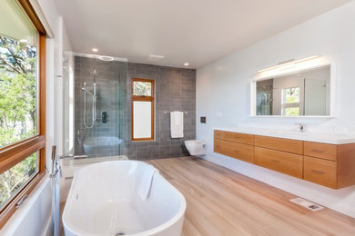 Bathroom - modern gray tile ceramic tile and brown floor bathroom idea in San Francisco with flat-panel cabinets, a wall-mount toilet and white countertops