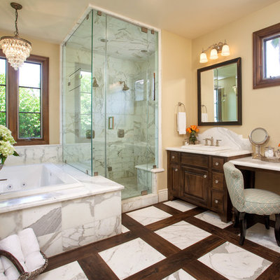 Inspiration for a tropical white tile and stone tile bathroom remodel in San Diego with raised-panel cabinets, dark wood cabinets and marble countertops
