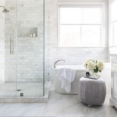 Inspiration for a mid-sized transitional master white tile and marble tile marble floor and white floor freestanding bathtub remodel in Sacramento with shaker cabinets, white cabinets, gray walls, an undermount sink, marble countertops, a hinged shower door and white countertops