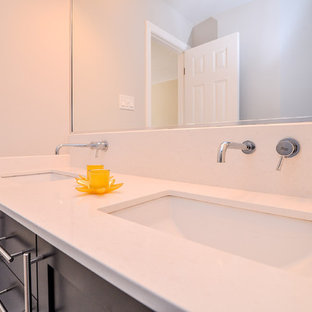Esempio di una stanza da bagno padronale minimal di medie dimensioni con lavabo sottopiano, ante in stile shaker, ante in legno bruno, top in quarzite, vasca sottopiano, vasca/doccia, WC a due pezzi, piastrelle beige, piastrelle di vetro, pareti beige e pavimento con piastrelle in ceramica
