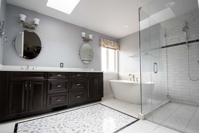 Cette image montre une grande salle de bain principale traditionnelle avec un placard avec porte à panneau surélevé, des portes de placard noires, une baignoire indépendante, une douche à l'italienne, WC séparés, un carrelage noir et blanc, du carrelage en marbre, un mur bleu, un sol en carrelage de céramique, un lavabo encastré, un plan de toilette en quartz modifié, un sol multicolore, une cabine de douche à porte battante, un plan de toilette blanc, une niche, meuble double vasque et meuble-lavabo encastré.