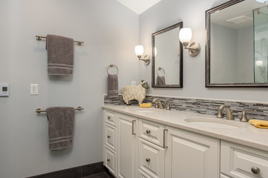 Bathroom - mid-sized transitional master gray tile and glass tile porcelain tile and black floor bathroom idea in Milwaukee with flat-panel cabinets, a wall-mount toilet, gray walls, a drop-in sink and quartzite countertops