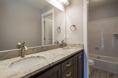 Inspiration for a large traditional family bathroom in Salt Lake City with raised-panel cabinets, dark wood cabinets, granite worktops, an alcove bath, white tiles, ceramic tiles, grey walls and ceramic flooring.