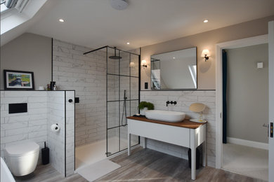 Photo of a contemporary bathroom in Hertfordshire with flat-panel cabinets, white cabinets, a corner shower, white tiles, grey walls, medium hardwood flooring, a vessel sink, brown floors, an open shower, white worktops, a single sink and a freestanding vanity unit.