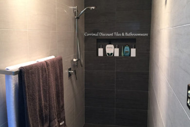Modelo de cuarto de baño minimalista de tamaño medio con ducha abierta, sanitario de dos piezas, baldosas y/o azulejos grises, baldosas y/o azulejos de porcelana, paredes blancas y suelo de baldosas de porcelana