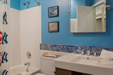 Inspiration for a mid-sized transitional 3/4 blue tile and glass tile porcelain tile and beige floor bathroom remodel in Baltimore with flat-panel cabinets, dark wood cabinets, a one-piece toilet, blue walls, an integrated sink and quartzite countertops