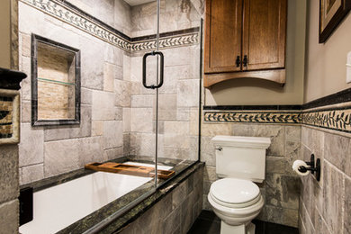 Large transitional 3/4 gray tile and slate tile slate floor bathroom photo in Milwaukee with shaker cabinets, medium tone wood cabinets, a two-piece toilet, beige walls, a vessel sink and granite countertops