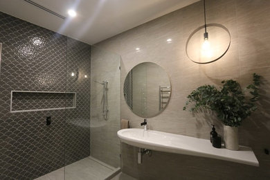 На фото: ванная комната среднего размера в стиле модернизм с открытым душем, бежевой плиткой, керамогранитной плиткой, бежевыми стенами, полом из керамогранита, подвесной раковиной, бежевым полом и открытым душем